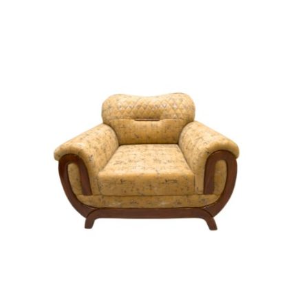 Mustard yellow single seater sofa with quilted backrest, wooden curved arms, and cushioned seat placed in a bright modern living room with wooden flooring.