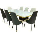 Modern marble top dining table with eight upholstered chairs in gray and white, featuring quilted design and gold accents, perfect for a luxury dining room.