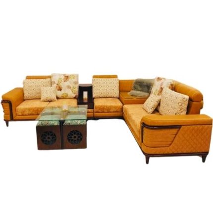 Modern L-shaped sectional corner sofa in mustard yellow fabric with printed and plain cushions, paired with glass-top wooden center tables.