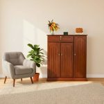 "Wooden storage cabinet placed under staircase, decorated with flower vase, digital clock, and fine wines box in a modern home interior."