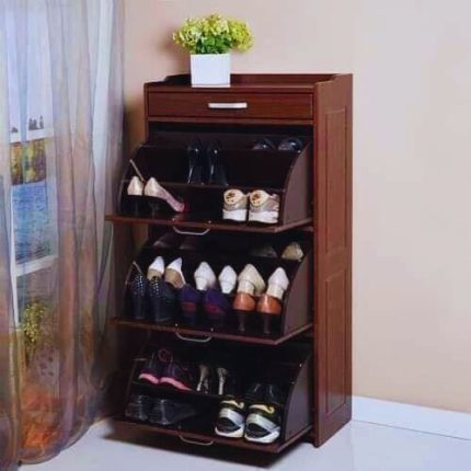 Wooden storage cabinet placed under staircase, decorated with flower vase, digital clock, and fine wines box in a modern home interior.