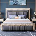 Elegant modern upholstered bed with beige padding and gold wooden frame in a stylish bedroom with sunburst mirror, bedside lamp, and floor-to-ceiling curtains.