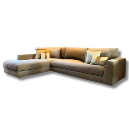 Modern beige L-shaped sectional sofa in a cozy living room with large windows, sheer curtains, circular wall mirrors, and two round white coffee tables on a textured rug.