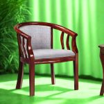 A stylish wooden lobby chair featuring a curved backrest and grey upholstered seat, set against a bright green background with plants in the corner.